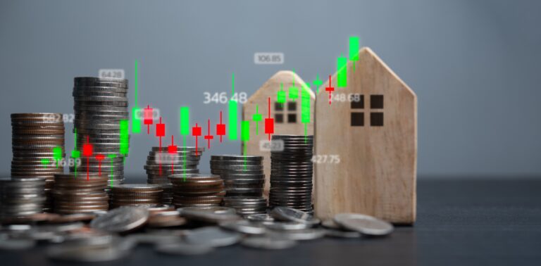 Coins and wooden houses with a stock market graph overlay representing real estate market trends and finance property.